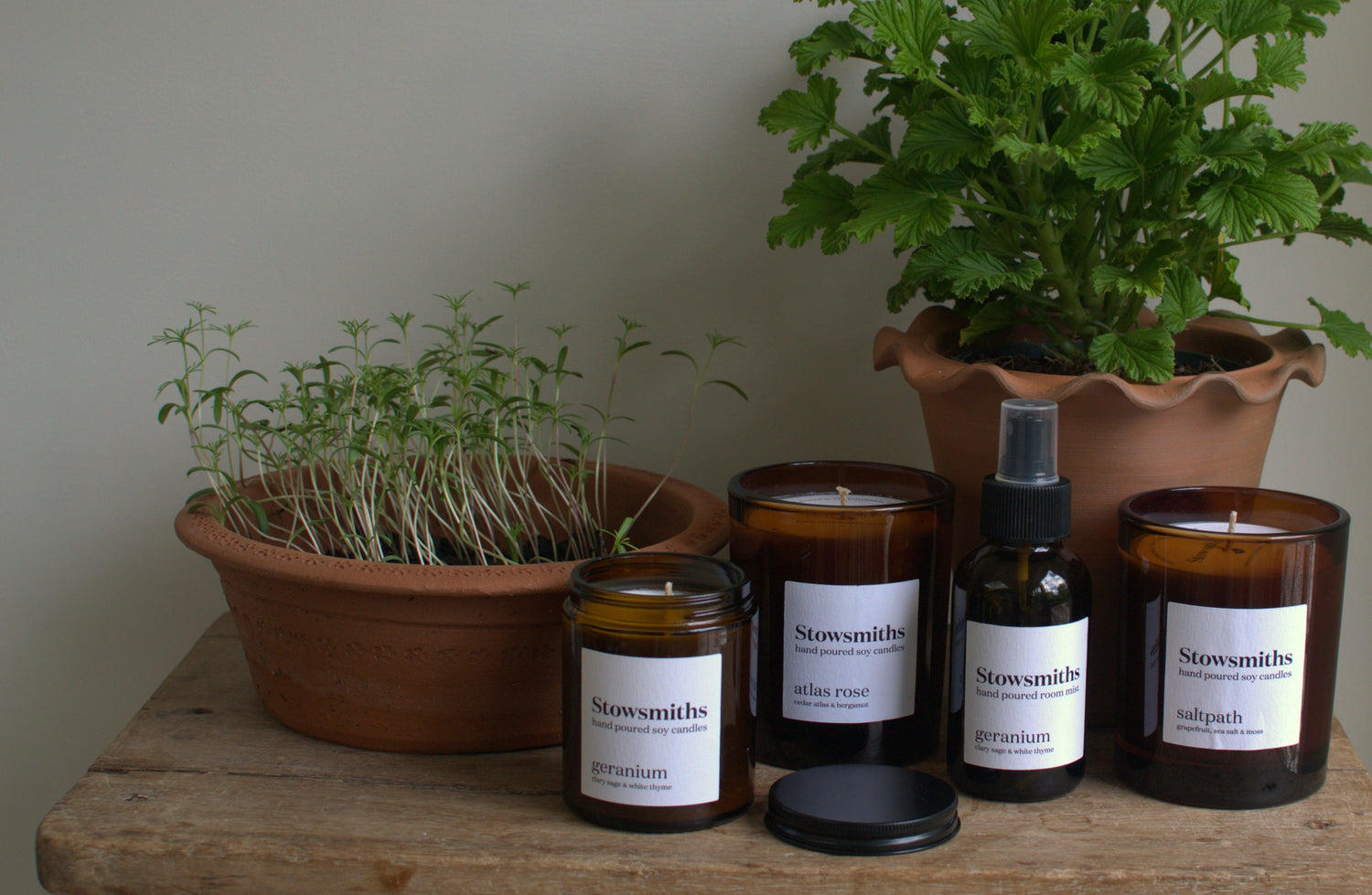 a collection of candles set against gardening terracotta pots