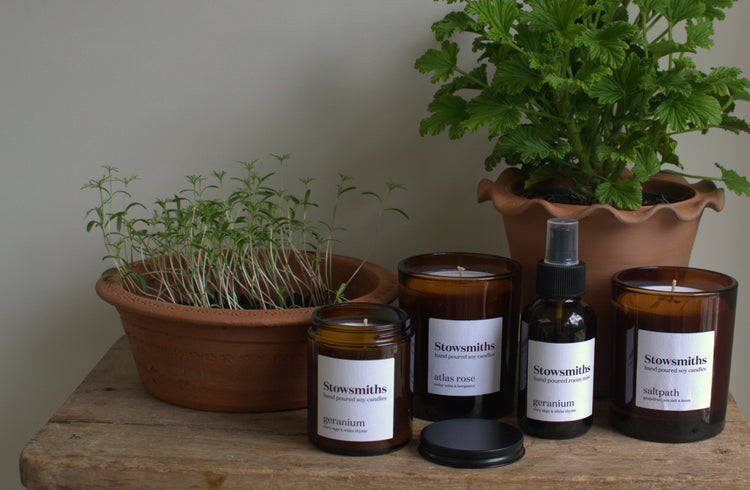 a collection of candles set against gardening terracotta pots